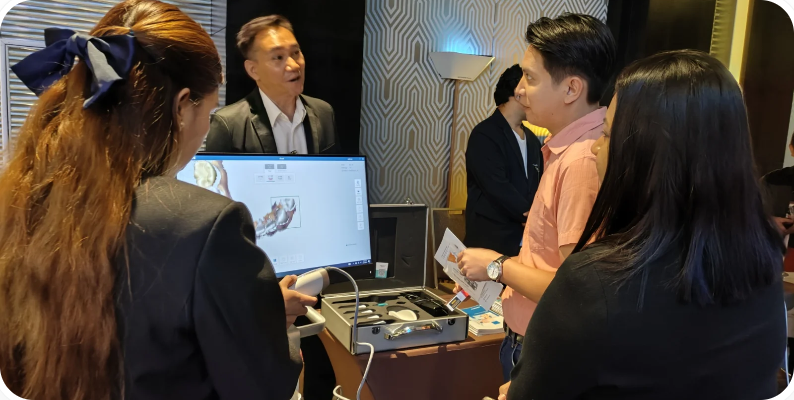 Dental professionals discussing digital scanning equipment at an SPMS product presentation